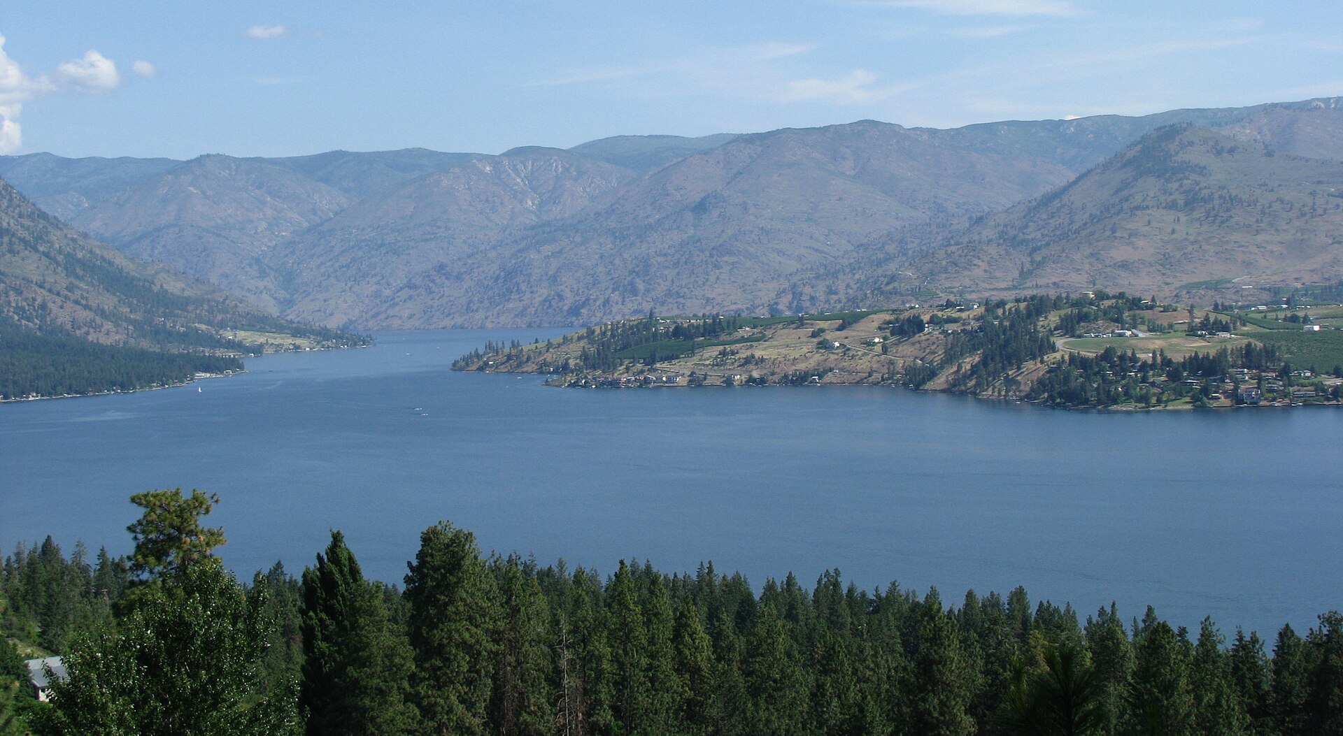 The deep blue waters of Lake Chelan framed by dry hills, seen from Navarre Coulee Road in Chelan County, Washington.