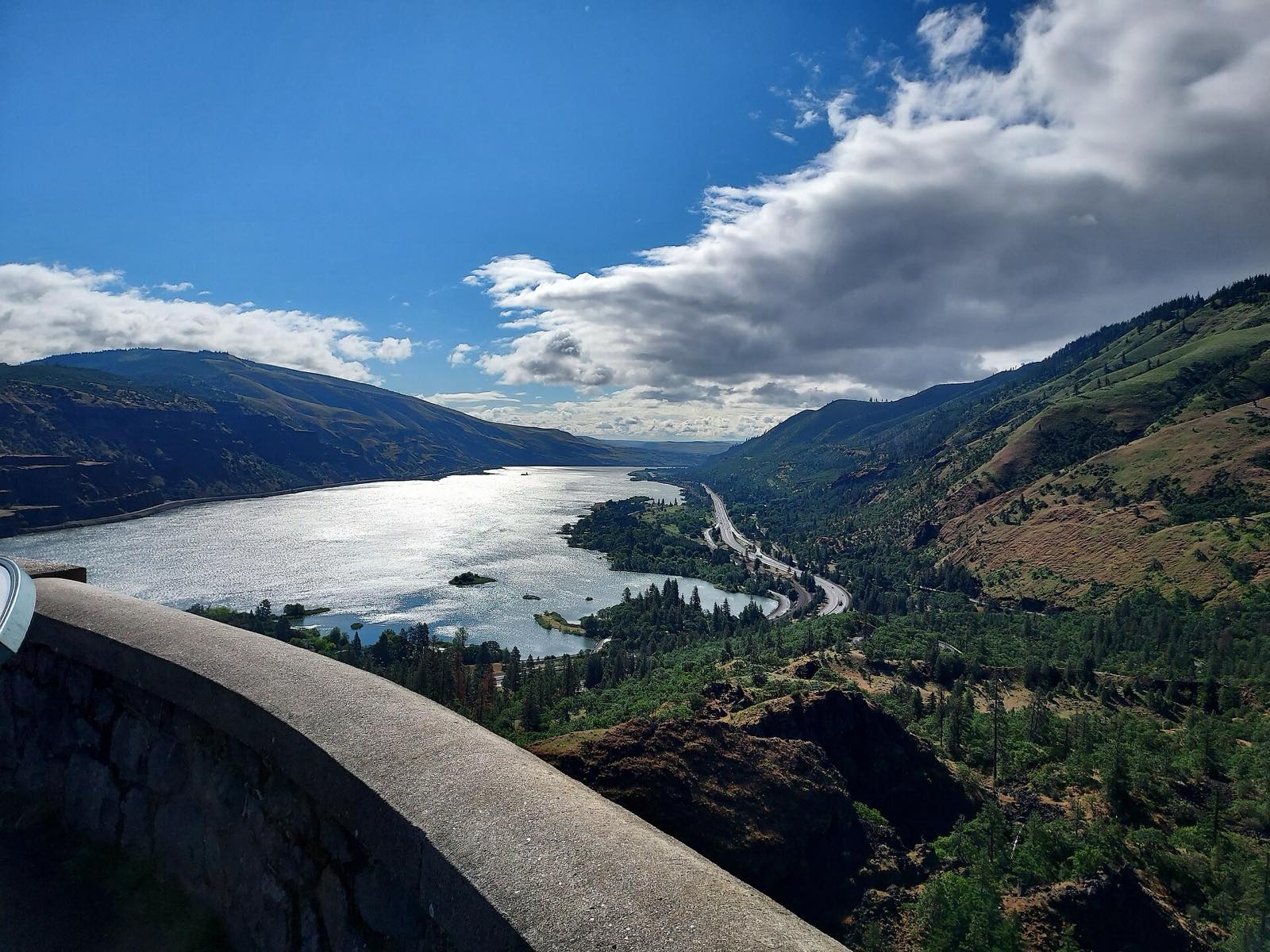 Aerial view from Rowena Crest Viewpoint overlooking the Columbia River winding through the Columbia River Gorge in Wasco County, Oregon, with the highway curving along the riverbank and forested hills on both sides