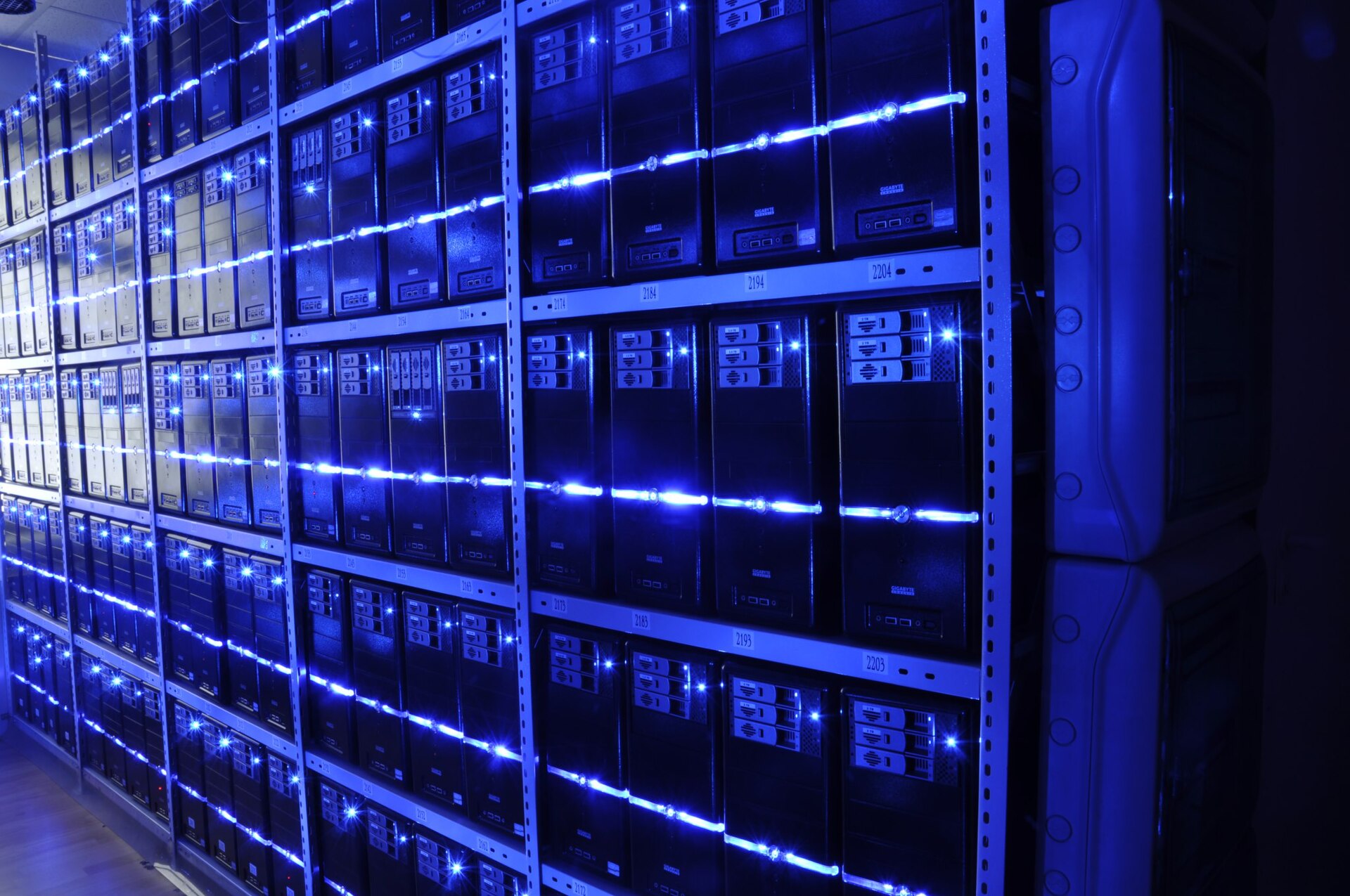 Long aisles of server racks and cabling inside a data center's main equipment hall.